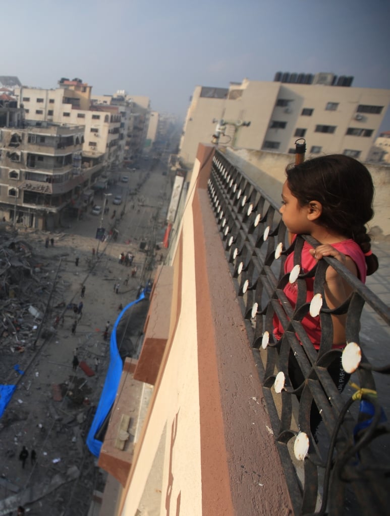 2024_Gaza_-A-Palestinian-girl-looks-from-above-a-building-at-the-destruction-of-a-residential-tower-__Mohammed-Zaanoun-scaled-aspect-ratio-375-497