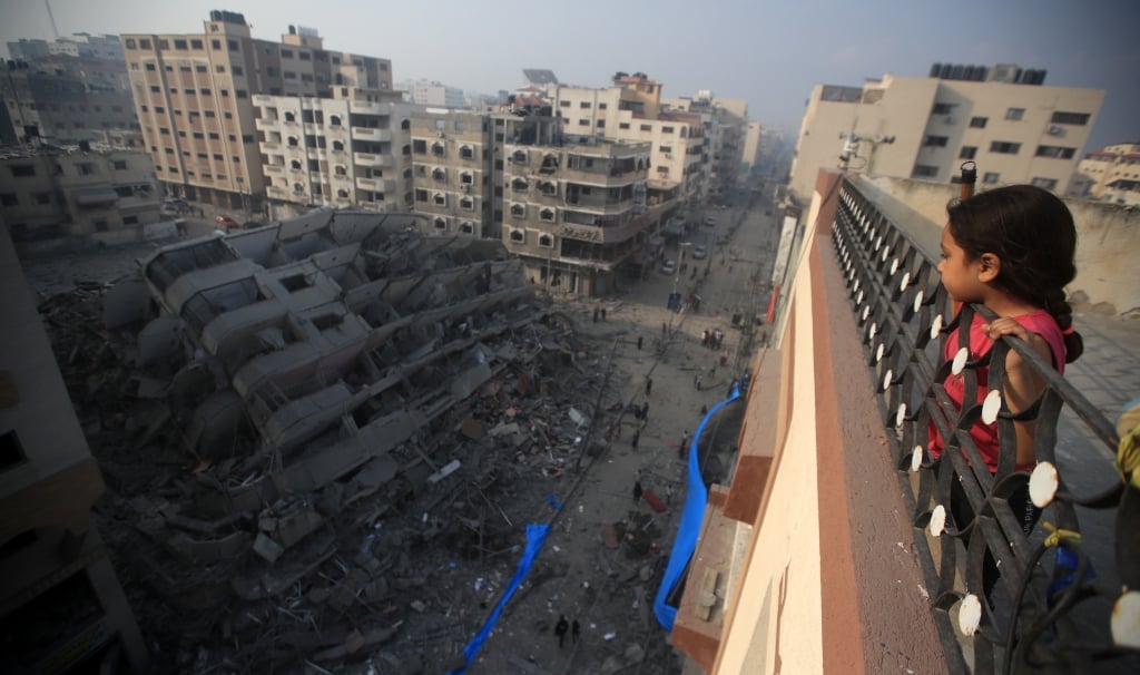 2024_Gaza_-A-Palestinian-girl-looks-from-above-a-building-at-the-destruction-of-a-residential-tower-__Mohammed-Zaanoun-scaled-aspect-ratio-1028-608