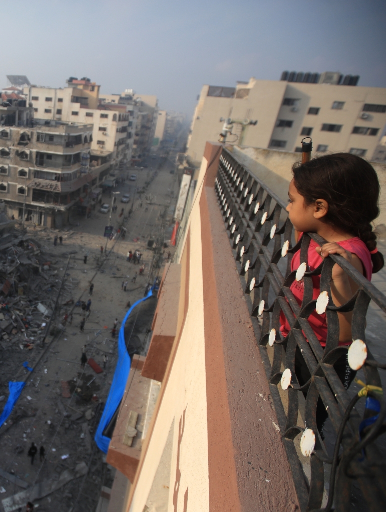 2024_Gaza_-A-Palestinian-girl-looks-from-above-a-building-at-the-destruction-of-a-residential-tower-__Mohammed-Zaanoun-scaled-aspect-ratio-375-497